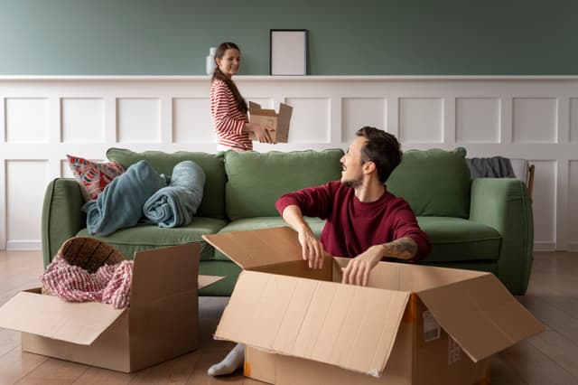 Gezin dat spullen in een nieuw huis draagt